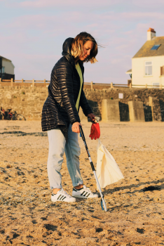 Nicky picking up beach litter with a litter picking stick
